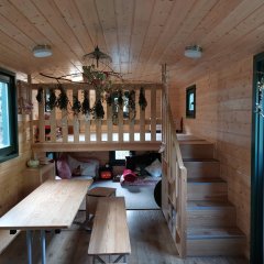 Blick in den Bauwagen. im hinteren Teil eine Treppe mit kleiner Spielecke, darunter eine Kuschelecke