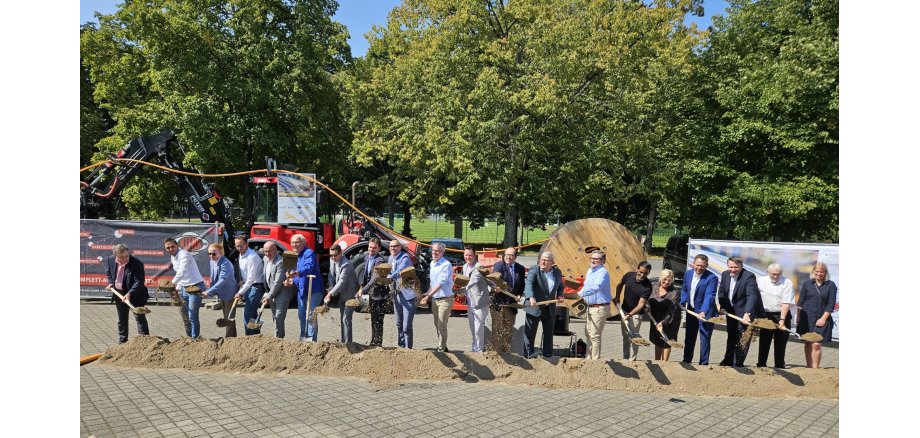 10 Bürgermeister der Landrat, Firma Klenk, Wirtschaftsförderung Bergstraße stehen alle mit einem Spaten in der Hand vor einem kleinen Erdwall und führen symbolisch den 1. Spatenstich aus